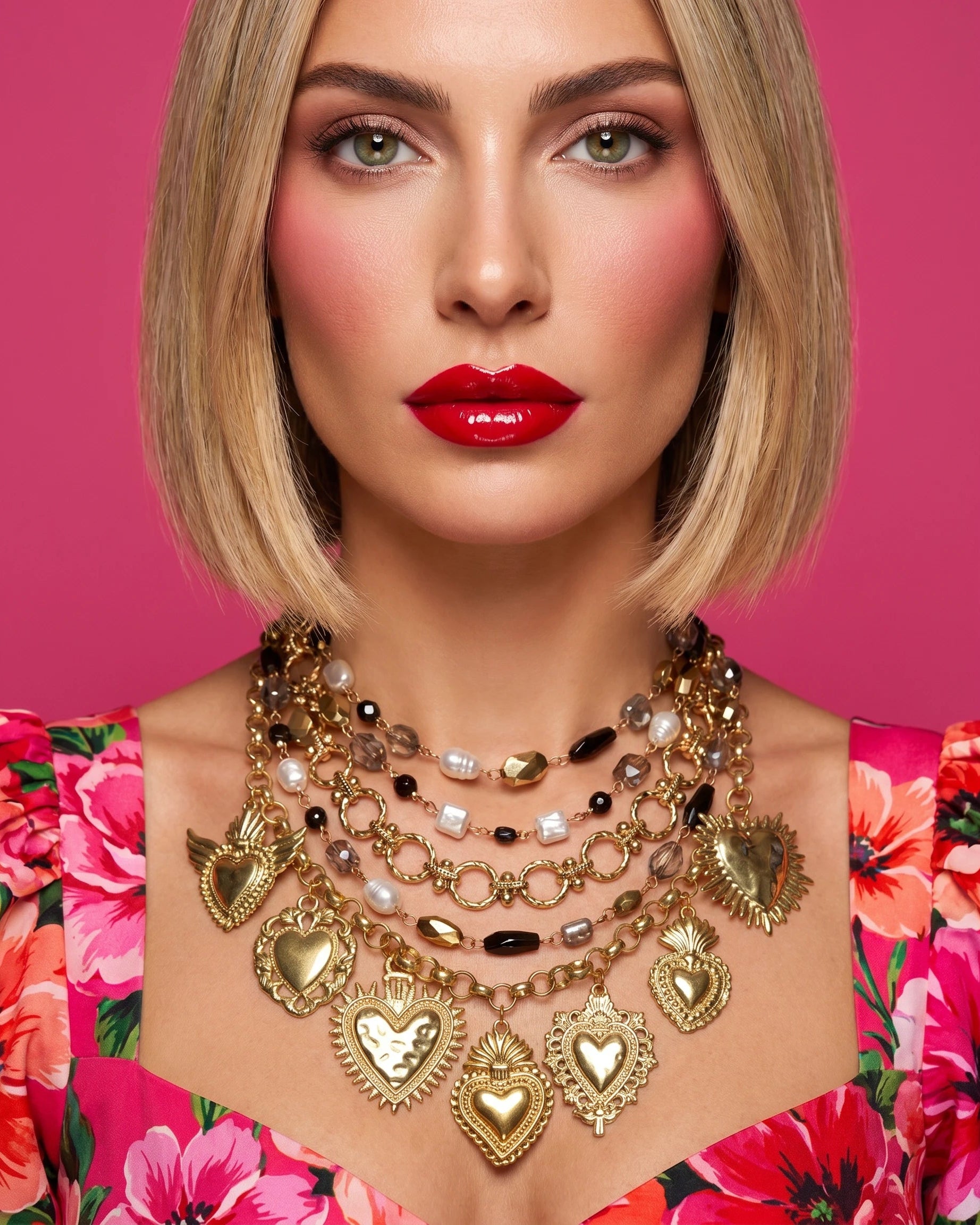 Woman wearing a gold necklace with heart pendants against a pink floral background