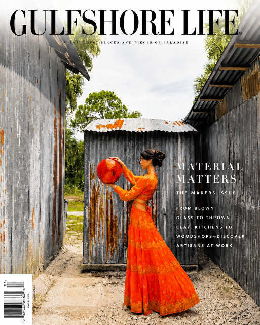 Gulfshore Life magazine cover featuring a woman in a bright orange dress standing between weathered metal buildings and holding a red-orange ball, with the masthead 'GULFSHORE LIFE' at the top and cover text on the right.