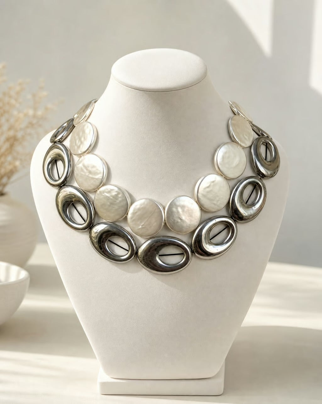 Necklace on a white mannequin bust with a neutral background
